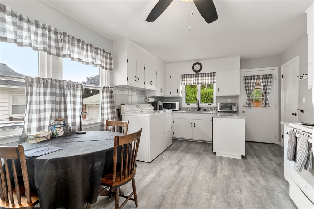27 Moore Street Chicopee, MA 01013 - Photo 11 of 24 a kitchen with white cabinets and wooden floors