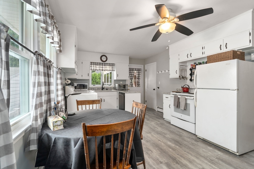 27 Moore Street Chicopee, MA 01013 - Photo 12 of 24 a kitchen with stainless steel appliances granite countertop a stove a refrigerator a dining table and chairs with wooden floor