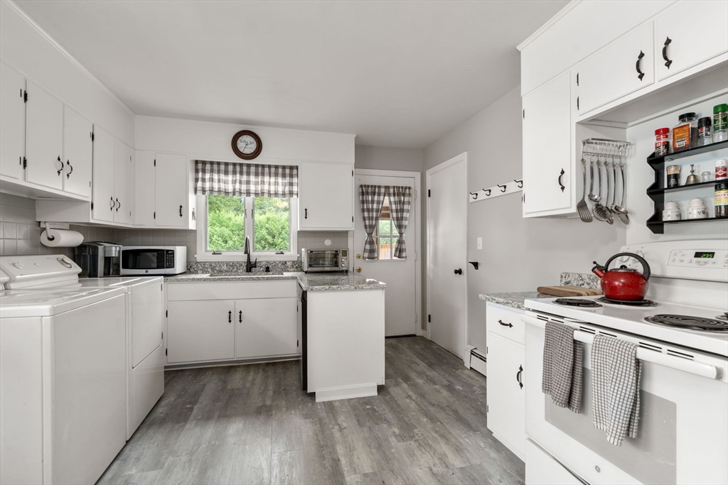27 Moore Street Chicopee, MA 01013 - Photo 13 of 24 a kitchen with a white stove top oven and white cabinets