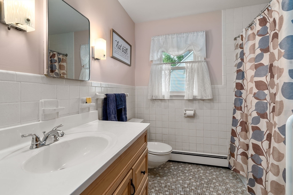 27 Moore Street Chicopee, MA 01013 - Photo 17 of 24 a bathroom with a sink a toilet and a mirror