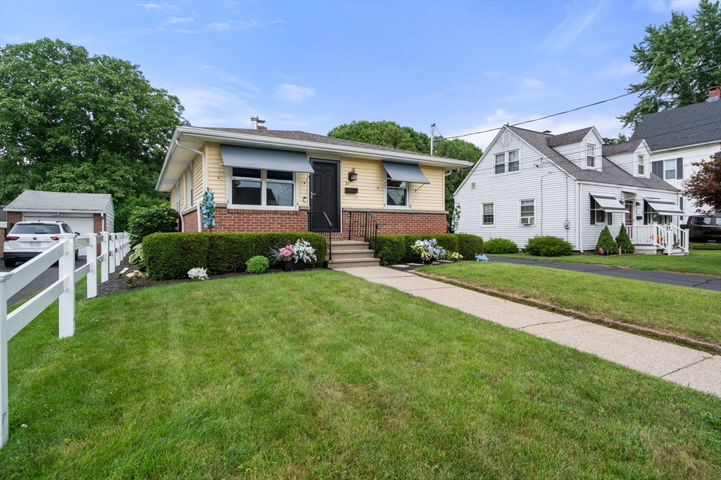 27 Moore Street Chicopee, MA 01013 - Photo 2 of 24 a front view of a house with a garden and plants