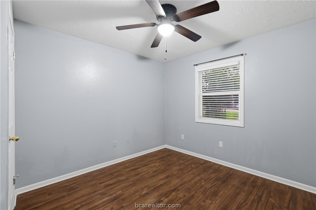 502 West 14th Street Bryan, TX 77803 - Photo 12 of 16 an empty room with wooden floor ceiling fan and windows