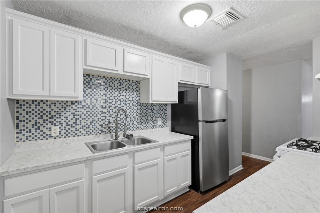 502 West 14th Street Bryan, TX 77803 - Photo 6 of 16 a kitchen with a sink and refrigerator