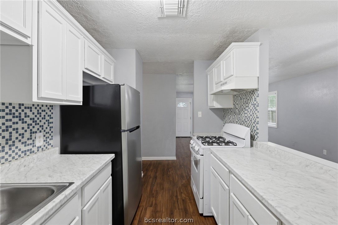 502 West 14th Street Bryan, TX 77803 - Photo 7 of 16 a kitchen with a sink a stove and refrigerator