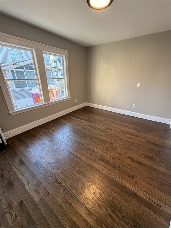 26 Malta Street, Unit 1 Boston, MA 02126 - Photo 11 of 14 an empty room with wooden floor and windows