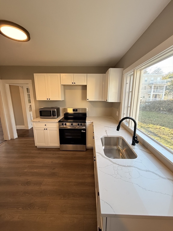 26 Malta Street, Unit 1 Boston, MA 02126 - Photo 4 of 14 a kitchen with a sink a stove and cabinets