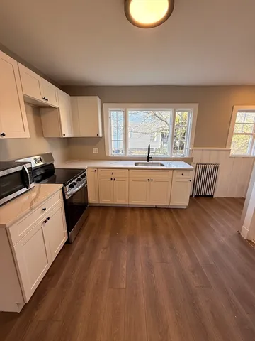 a kitchen with wooden floors and white appliances
