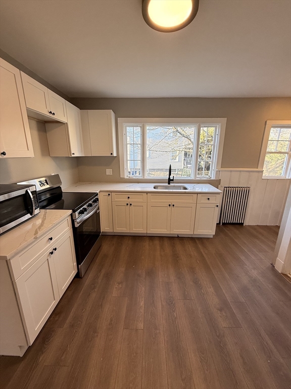 26 Malta Street, Unit 1 Boston, MA 02126 - Photo 5 of 14 a kitchen with wooden floors and white appliances