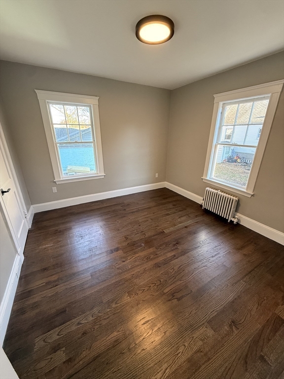 26 Malta Street, Unit 1 Boston, MA 02126 - Photo 9 of 14 an empty room with wooden floor and windows