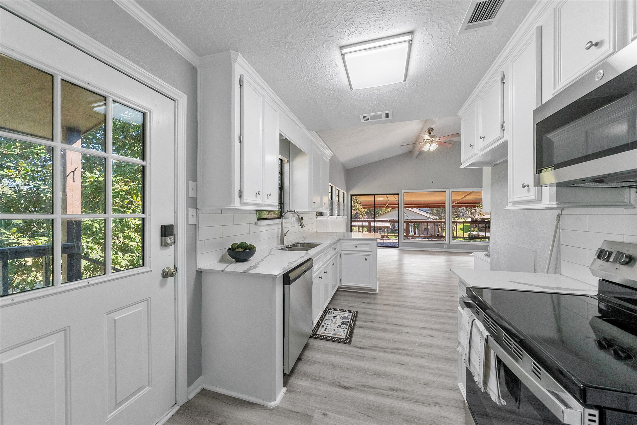 124 Timbo Trail Livingston, TX 77351 - Photo 23 of 45 a kitchen with stainless steel appliances a stove a sink and white cabinets with wooden floor