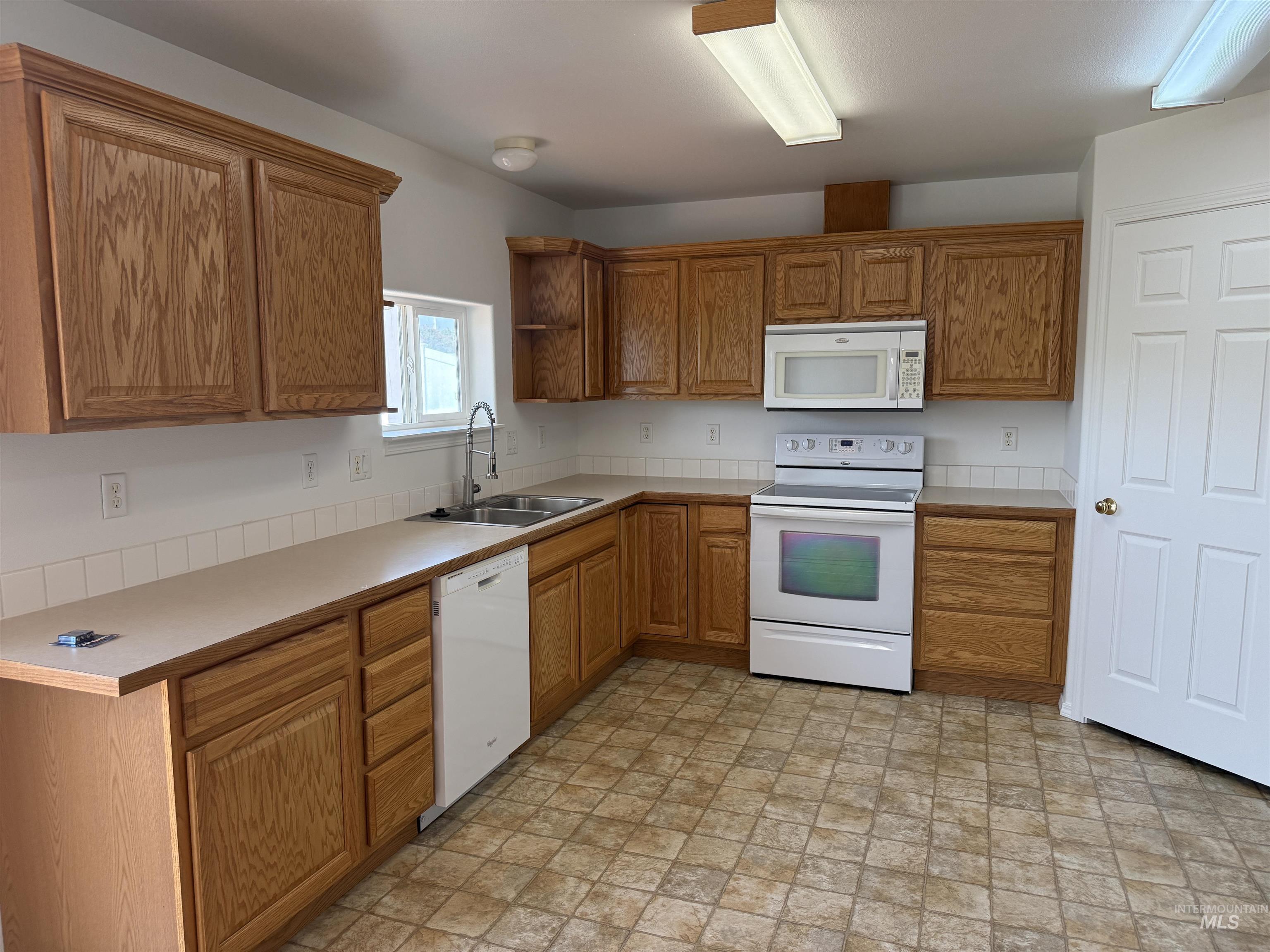 523 Morning Dove Way Marsing, ID 83639 - Photo 12 of 23 Kitchen featuring white appliances, wood finish cabinets, and light countertops