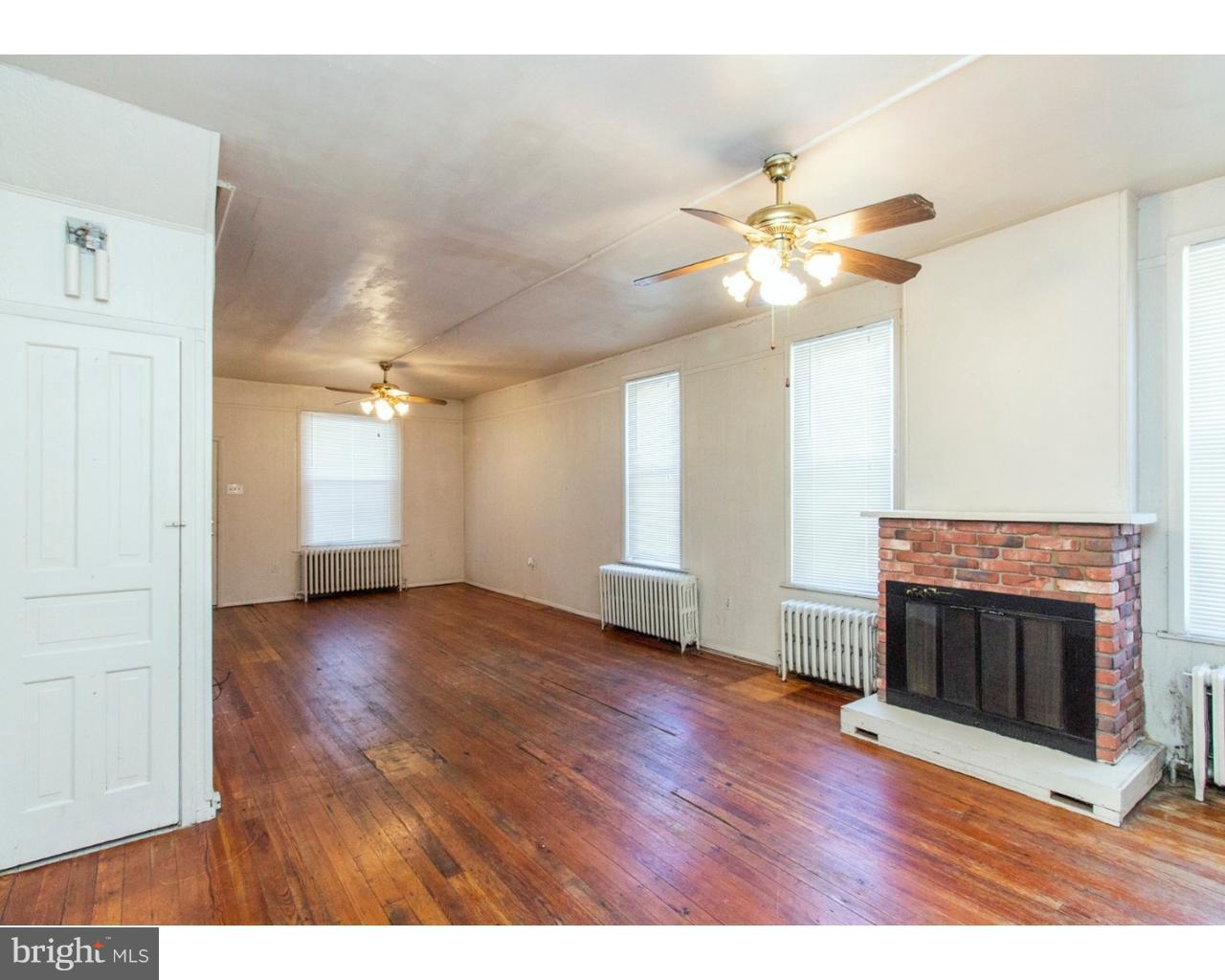 4359 Mitchell Street Philadelphia, PA 19128 - Photo 9 of 23 a view of a livingroom with a fireplace a ceiling fan and wooden floor