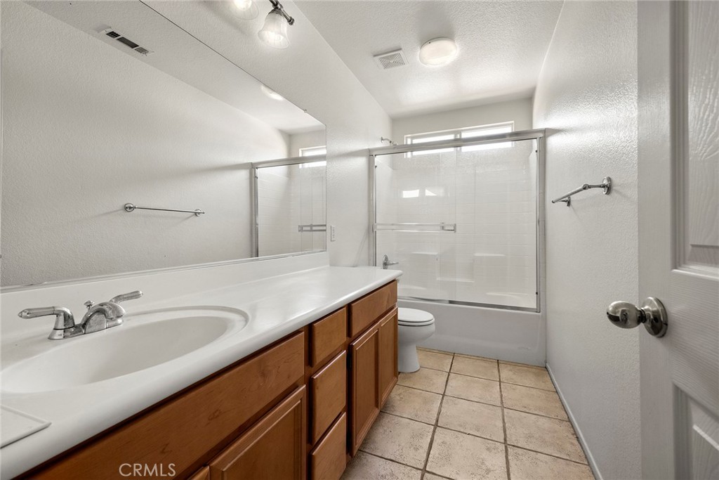 12351 Mesa Grove Drive Riverside, CA 92503 - Photo 19 of 32 a bathroom with a granite countertop sink a toilet and shower