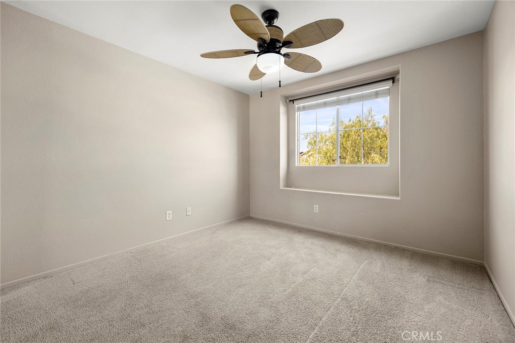 12351 Mesa Grove Drive Riverside, CA 92503 - Photo 20 of 32 an empty room with a chandelier fan and windows