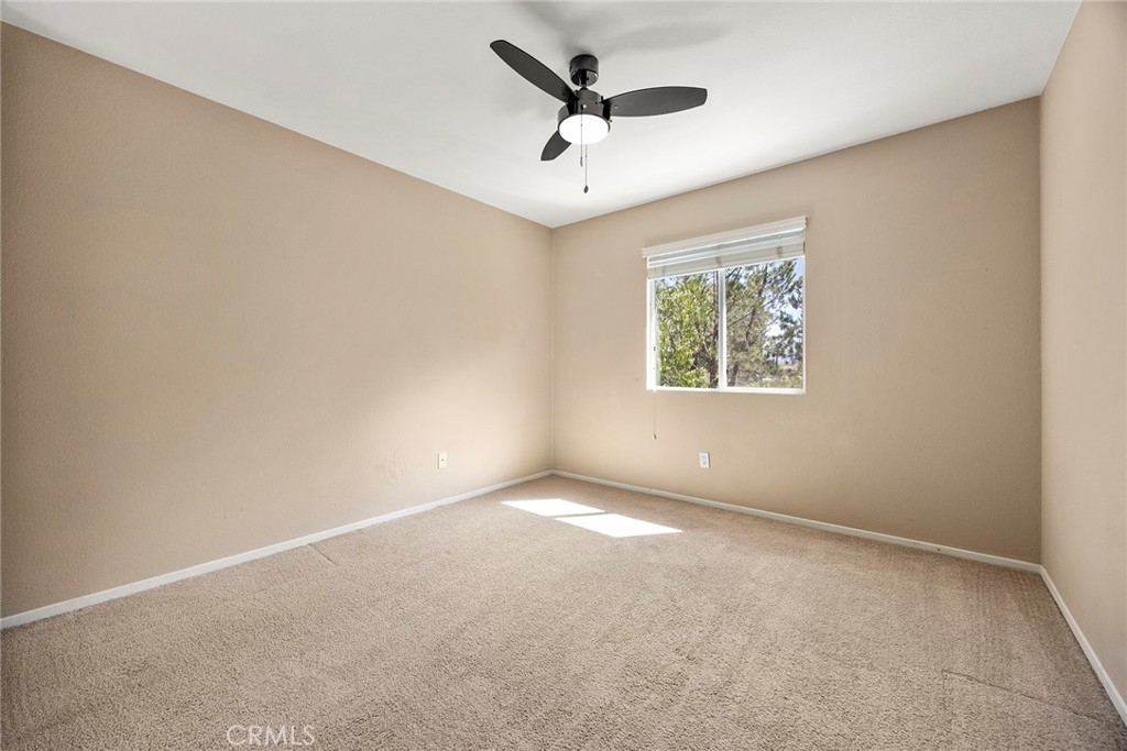 12351 Mesa Grove Drive Riverside, CA 92503 - Photo 21 of 32 an empty room with windows and ceiling fan