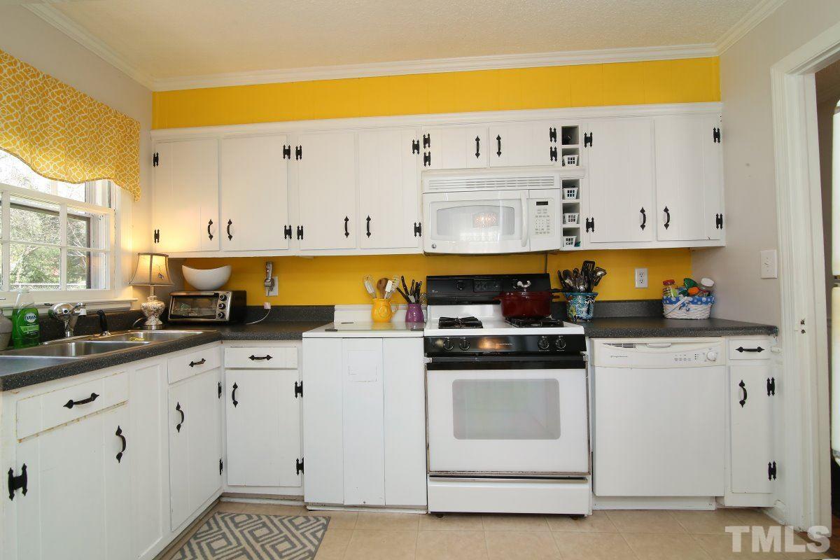 2748 Layden Street Raleigh, NC 27603 - Photo 14 of 25 a kitchen with granite countertop white cabinets and white appliances