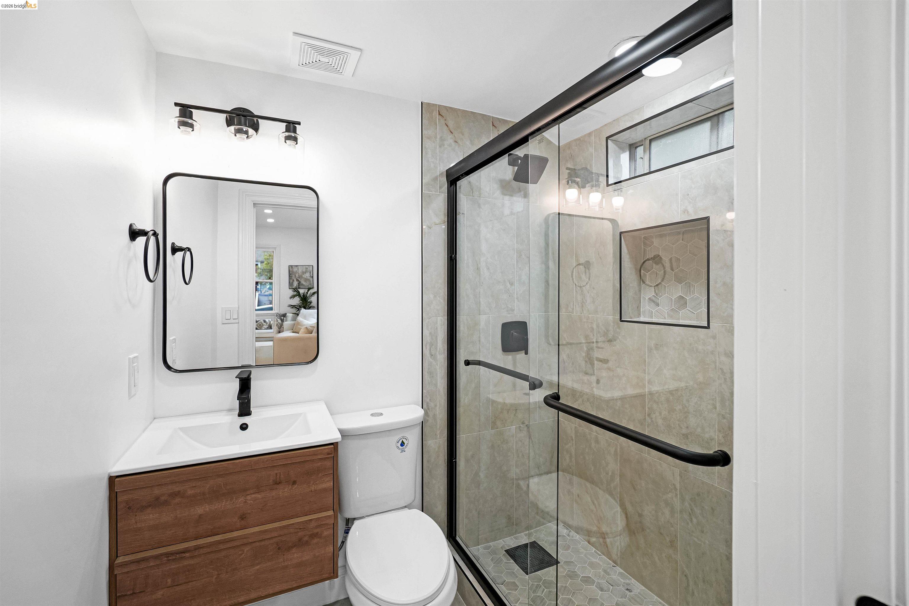 1812 Woolsey Street Berkeley, CA 94703 - Photo 14 of 48 Modern bathroom featuring a glass-enclosed shower with tiled walls and a hex-tile floor