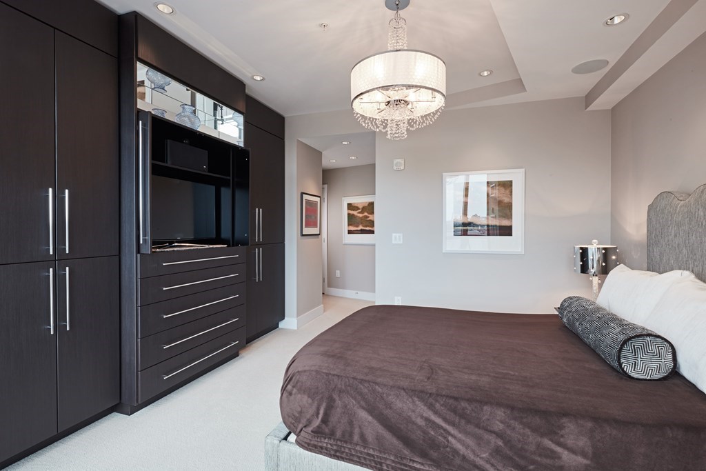 110 Stuart Street, Unit 18G Boston, MA 02116 - Photo 12 of 21 a bedroom with a large bed and a chandelier