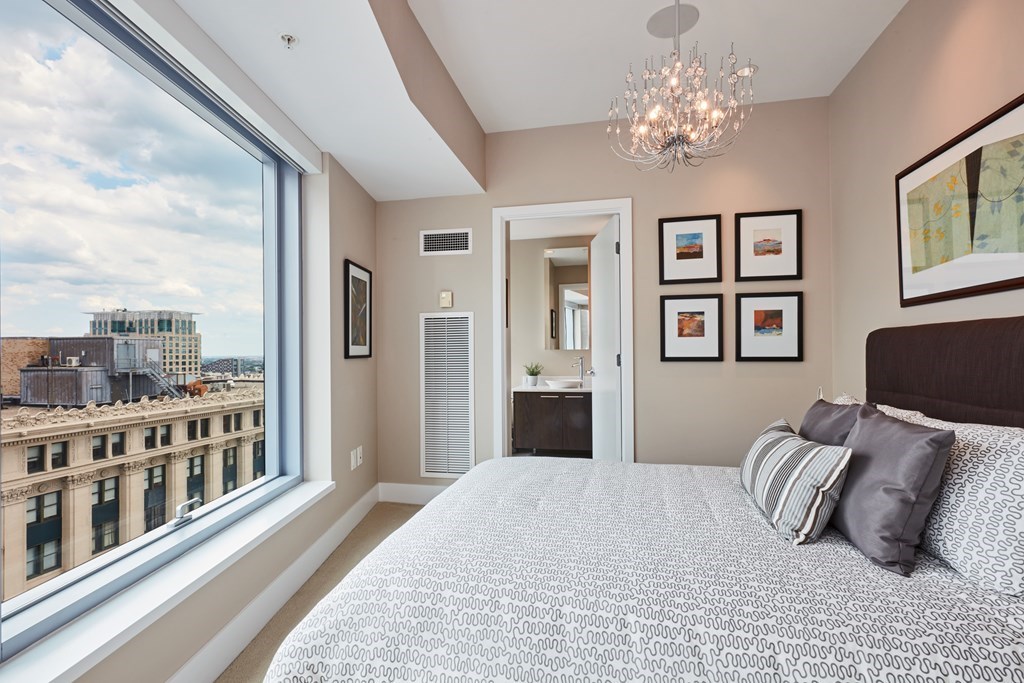110 Stuart Street, Unit 18G Boston, MA 02116 - Photo 9 of 21 a bedroom with a large bed and a chandelier