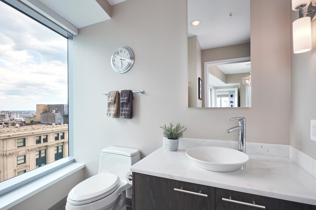 110 Stuart Street, Unit 18G Boston, MA 02116 - Photo 10 of 21 a bathroom with a granite countertop sink a toilet and a mirror