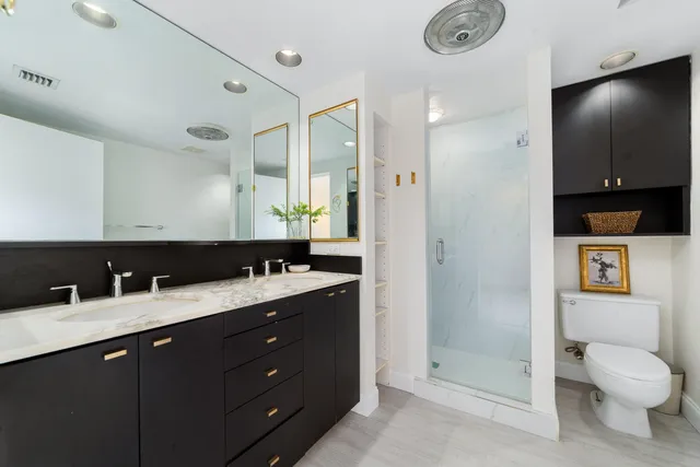 a bathroom with a sink a toilet and shower