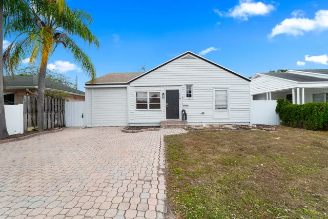 a view of a house with a yard and potted plants
