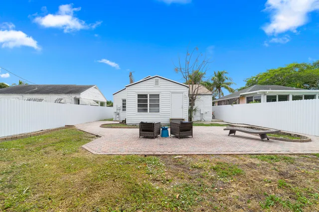 a backyard of a house with table and chairs