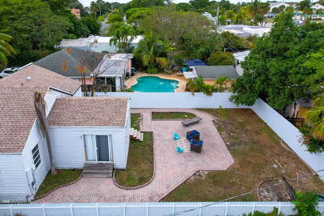 an aerial view of a house with swimming pool and large trees