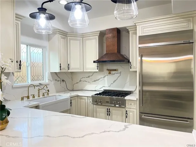 a kitchen with stainless steel appliances kitchen island a stove a sink and a refrigerator