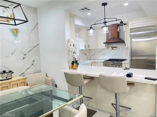 a kitchen with stainless steel appliances granite countertop a sink and a refrigerator