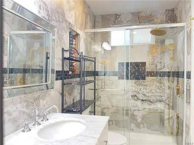 a bathroom with a sink mirror and shower