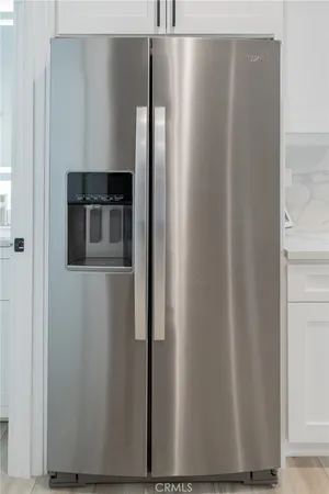 a metallic refrigerator freezer sitting inside of a kitchen