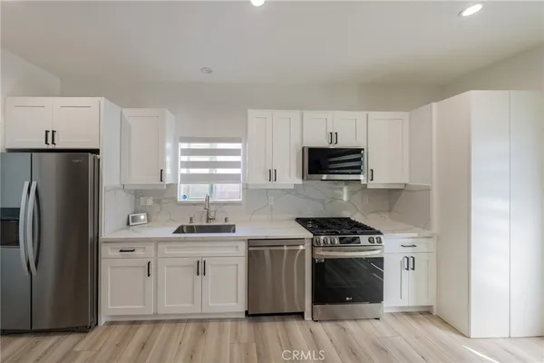 a kitchen with white cabinets and stainless steel appliances