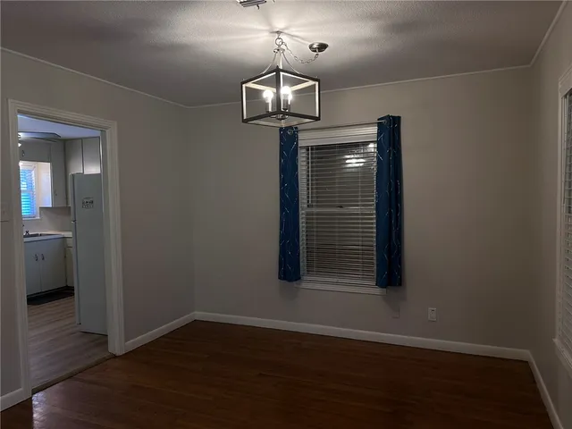 a view of a room with wooden floor staircase and a kitchen space