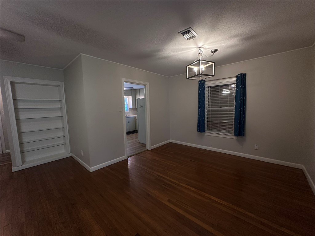 4002 Lowman Street Corpus Christi, TX 78411 - Photo 5 of 18 an empty room with wooden floor chandelier and windows