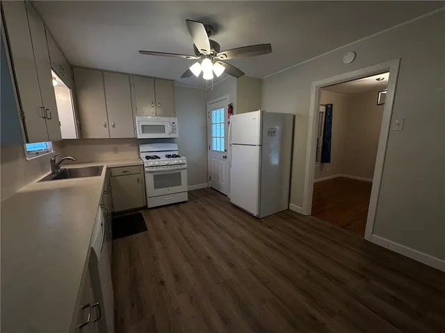 a kitchen with wooden floor and stainless steel appliances
