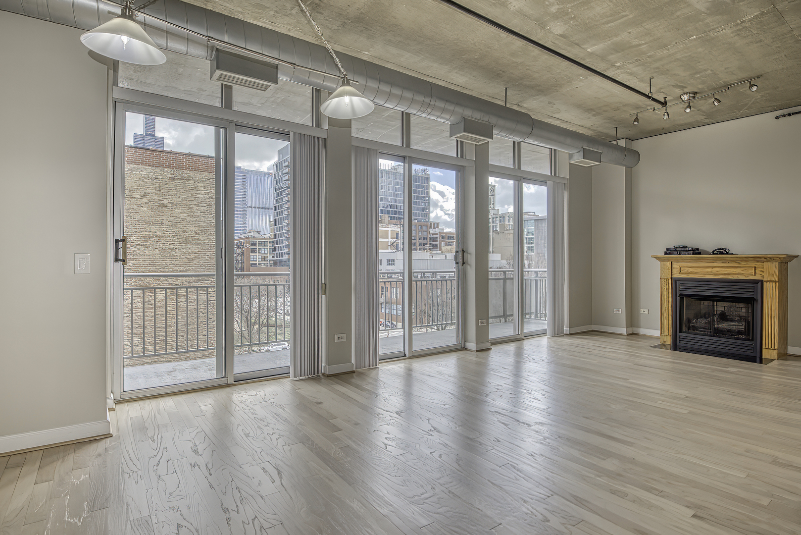 111 South Morgan Street, Unit 518 Chicago, IL 60607 - Photo 3 of 18 a view of a livingroom with wooden floor and a fireplace