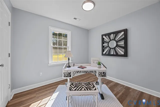a view of empty room with window and wooden floor