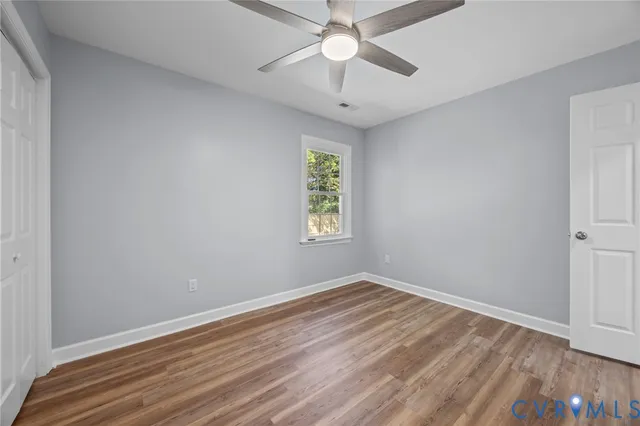 a view of an empty room with wooden floor
