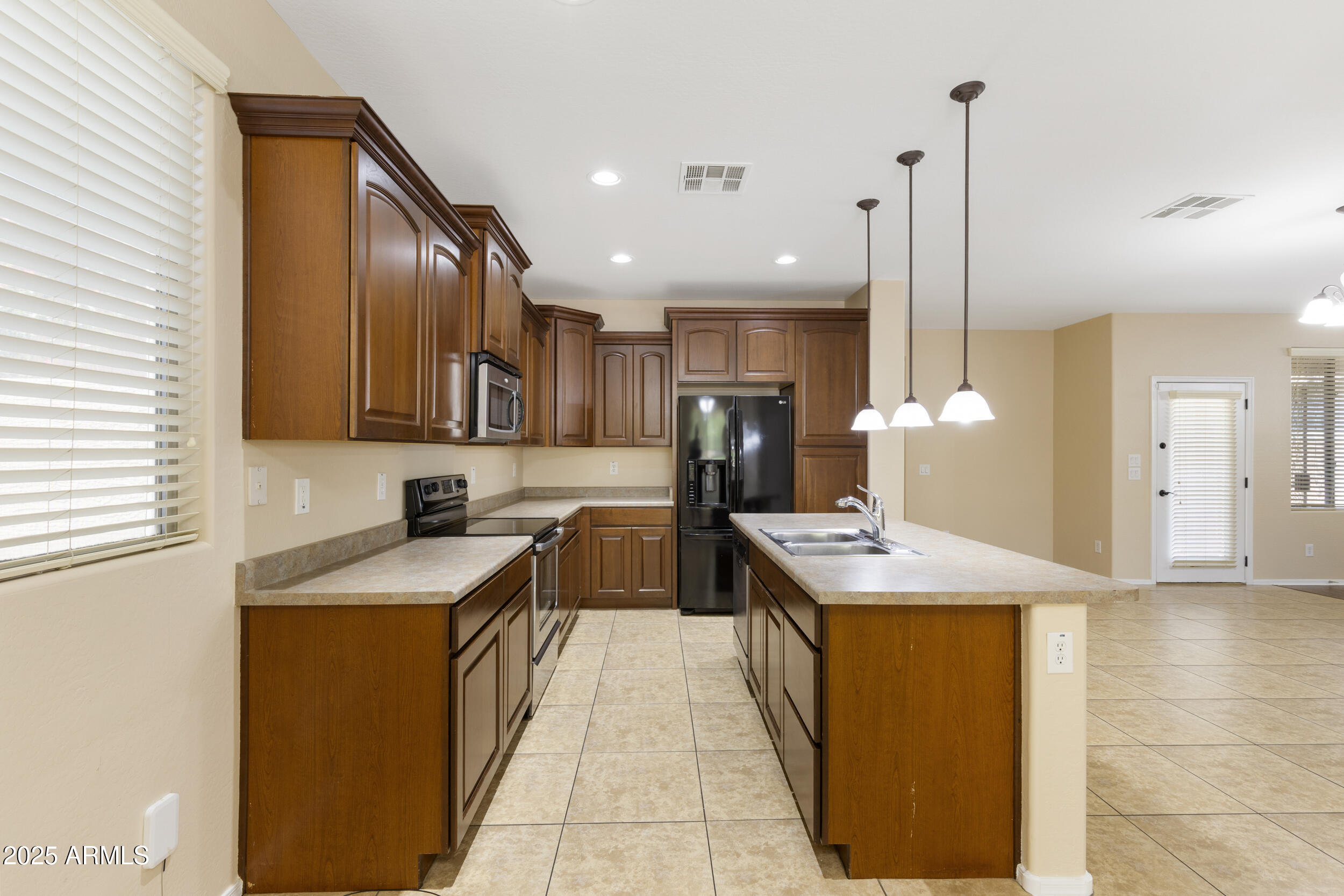 1870 South Colt Drive Gilbert, AZ 85295 - Photo 17 of 42 a kitchen with stainless steel appliances granite countertop a sink a stove and a wooden floors