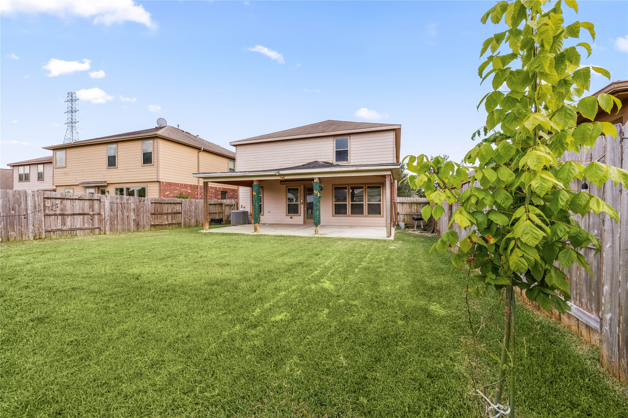 22414 Bellwick Ridge Lane Katy, TX 77449 - Photo 13 of 16 Spacious backyard with lush green grass, featuring a covered patio perfect for outdoor entertaining and relaxation.