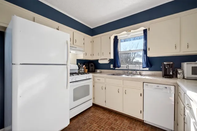 a kitchen with white cabinets and white appliances