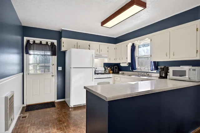 a kitchen with refrigerator and cabinets