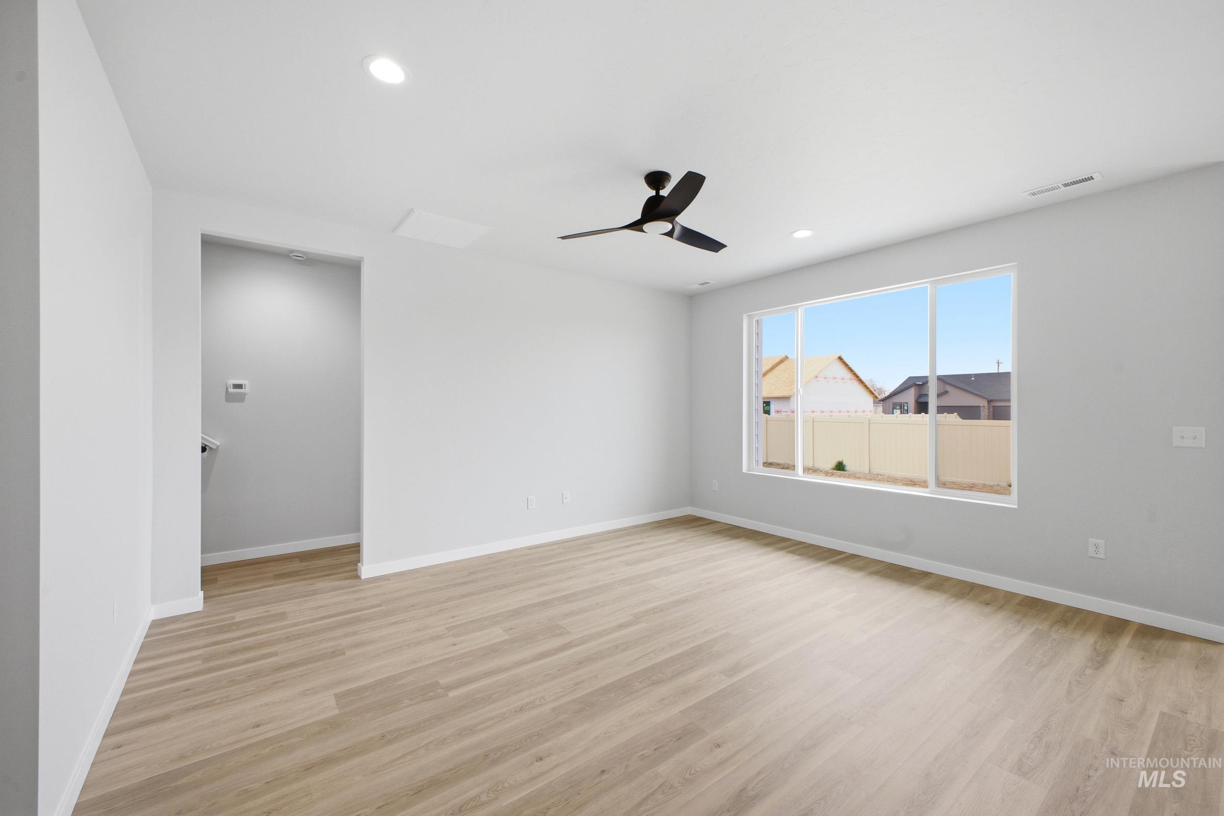 14104 Shiny Spruce Street Caldwell, ID 83607 - Photo 7 of 20 Spacious interior featuring wood-finish flooring, a contemporary ceiling fan, recessed lighting, and a large multi-pane window