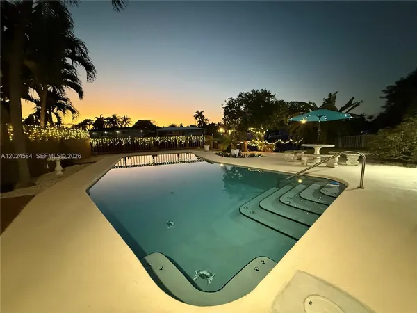 a view of swimming pool with outdoor seating and lake