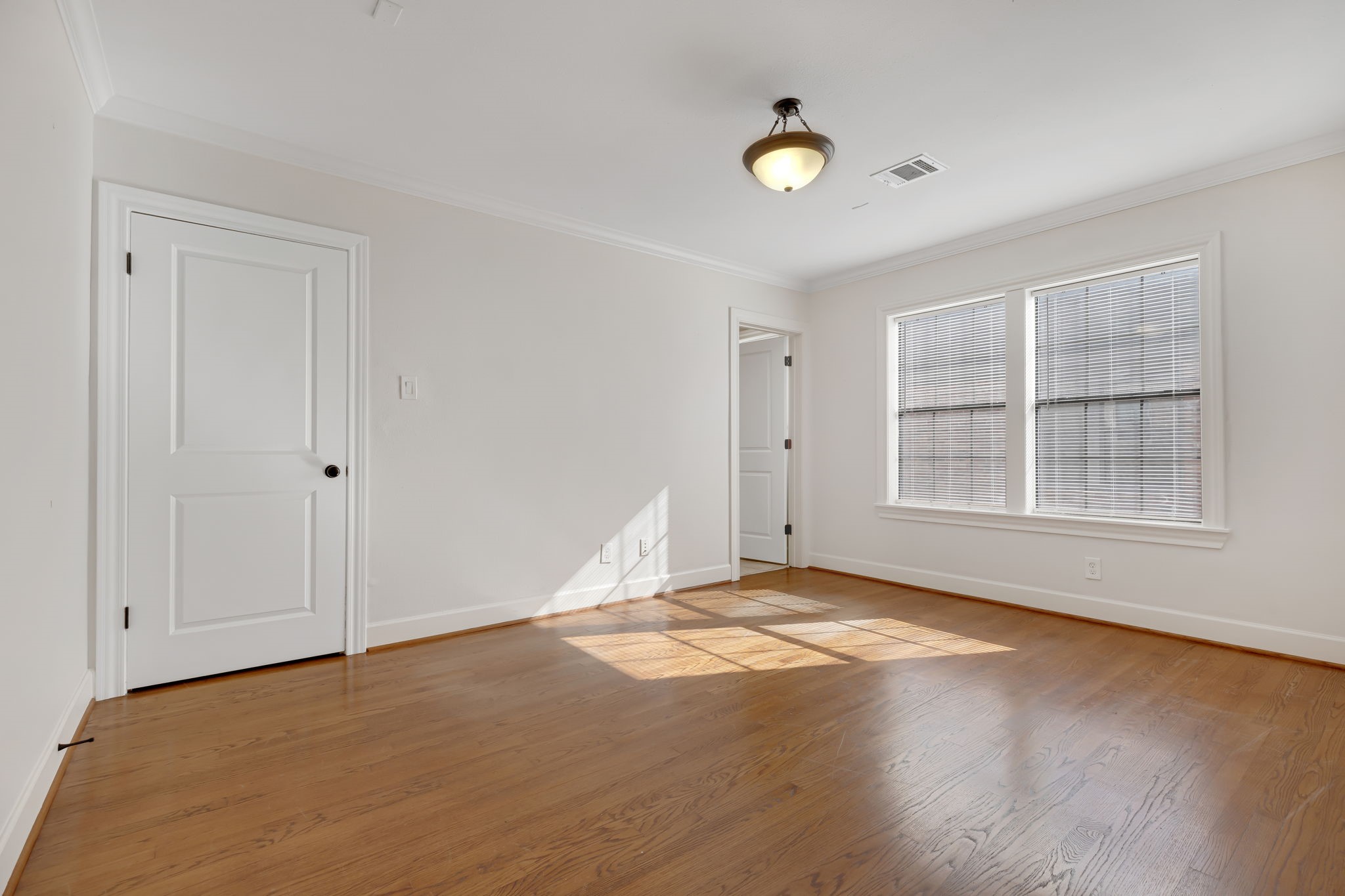 2306 Blodgett Street, Unit 2 Houston, TX 77004 - Photo 9 of 12 a view of an empty room with a window and wooden floor