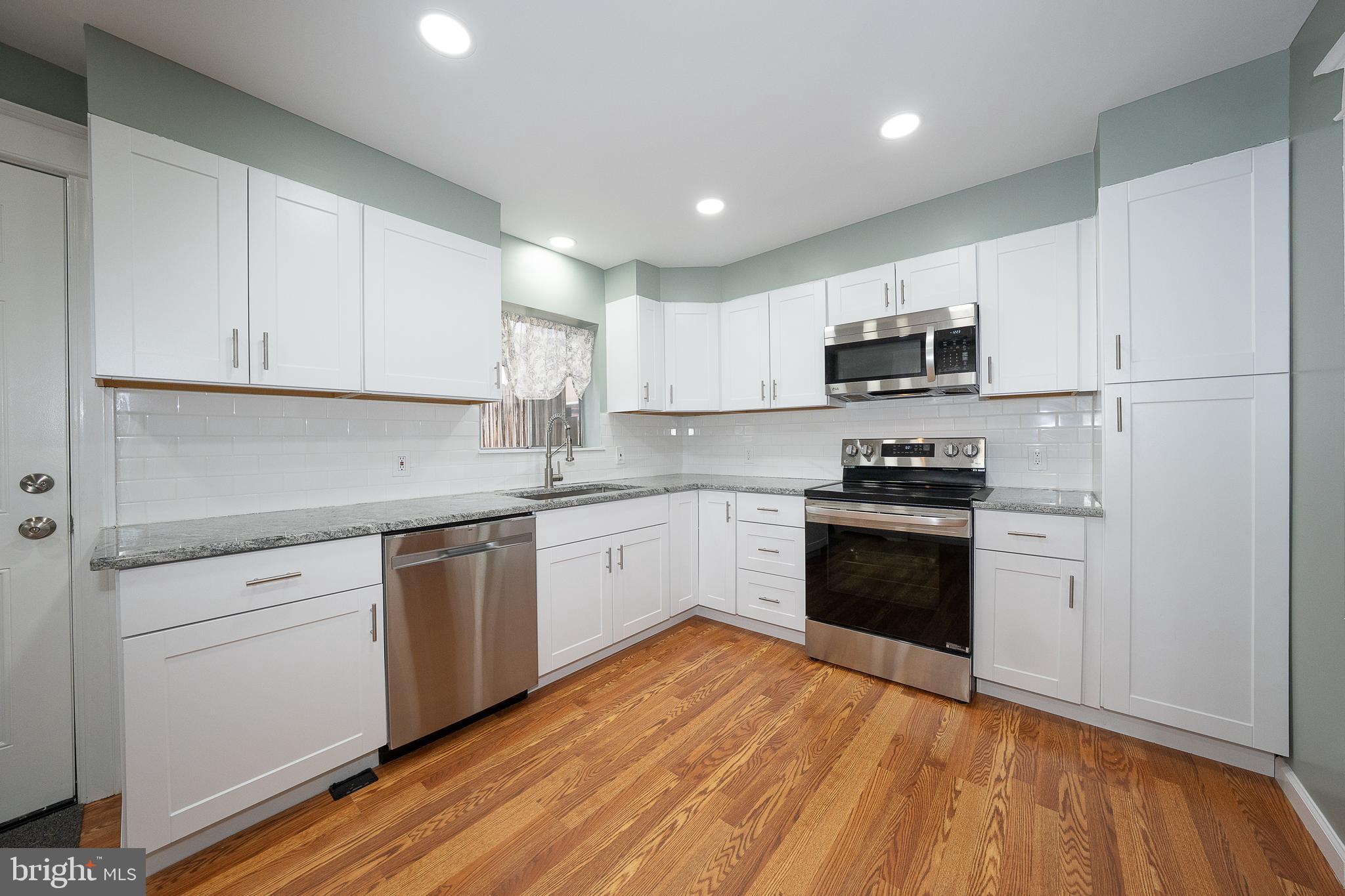 500 Elm Avenue Upper Darby, PA 19082 - Photo 4 of 35 a kitchen with granite countertop a refrigerator stove top oven and sink
