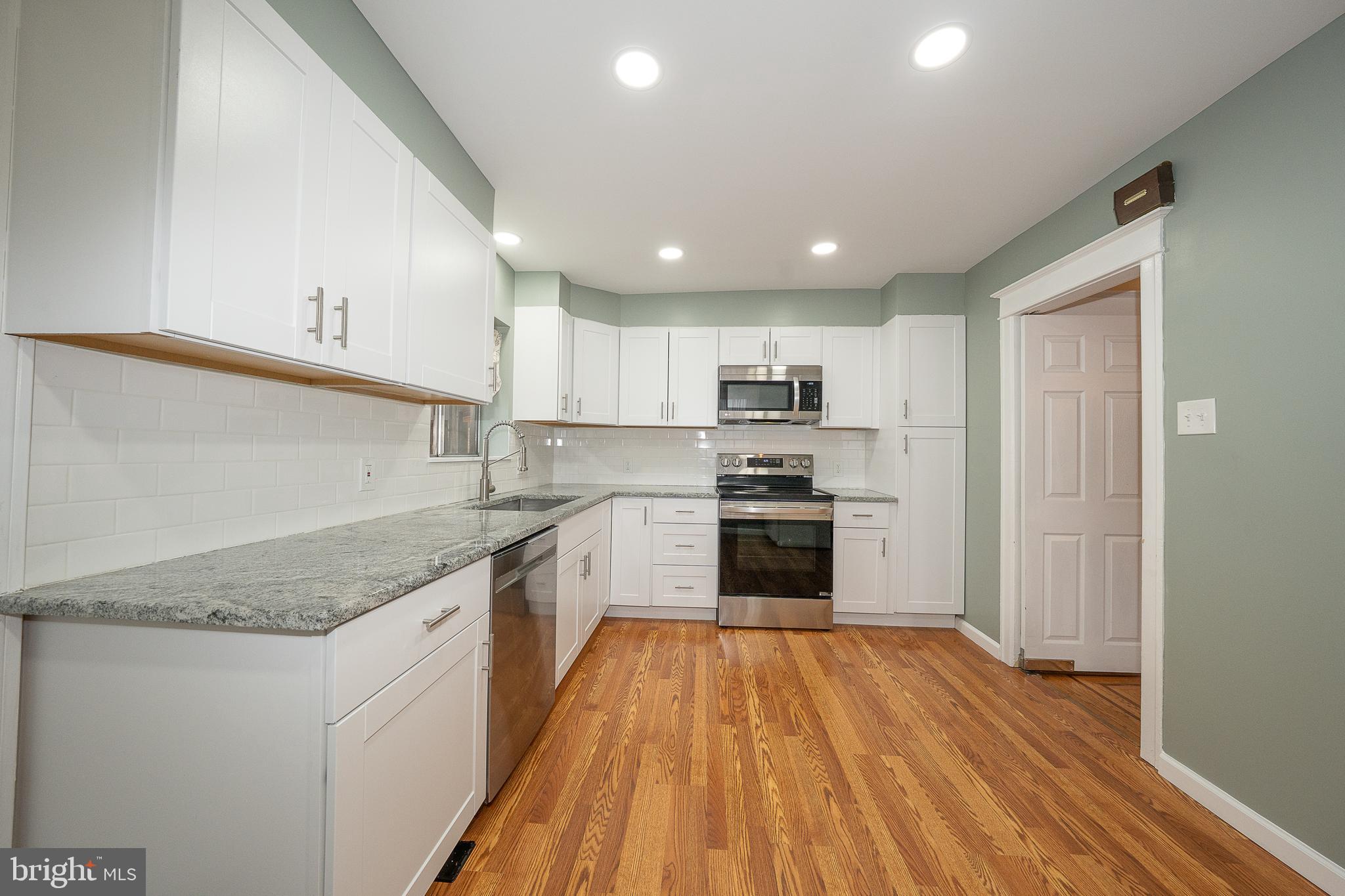 500 Elm Avenue Upper Darby, PA 19082 - Photo 5 of 35 a kitchen with stainless steel appliances granite countertop a sink dishwasher a refrigerator and a stove with wooden floors