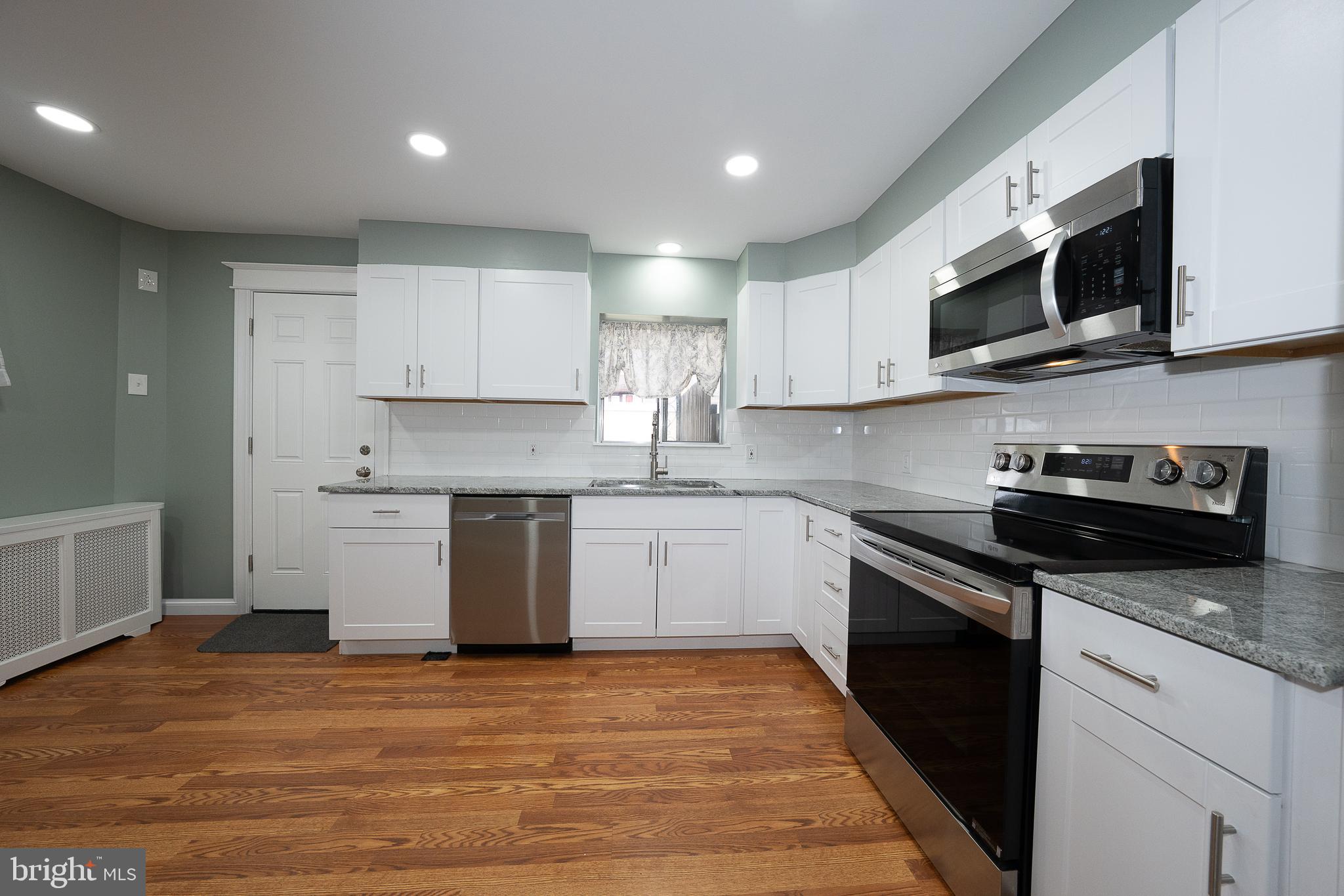 500 Elm Avenue Upper Darby, PA 19082 - Photo 6 of 35 a kitchen with stainless steel appliances granite countertop a sink and a stove top oven