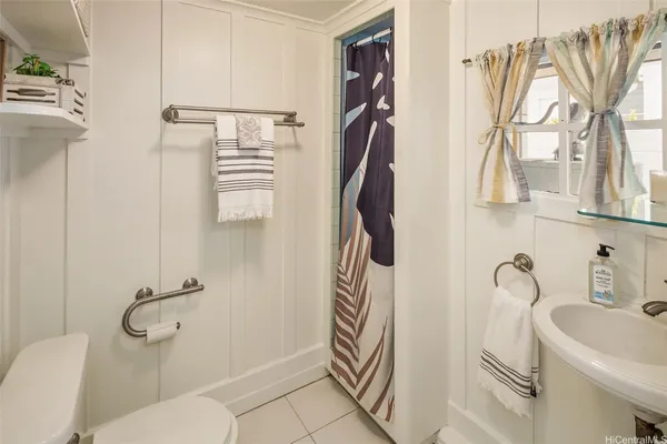 a bathroom with a sink a toilet and a shower curtain